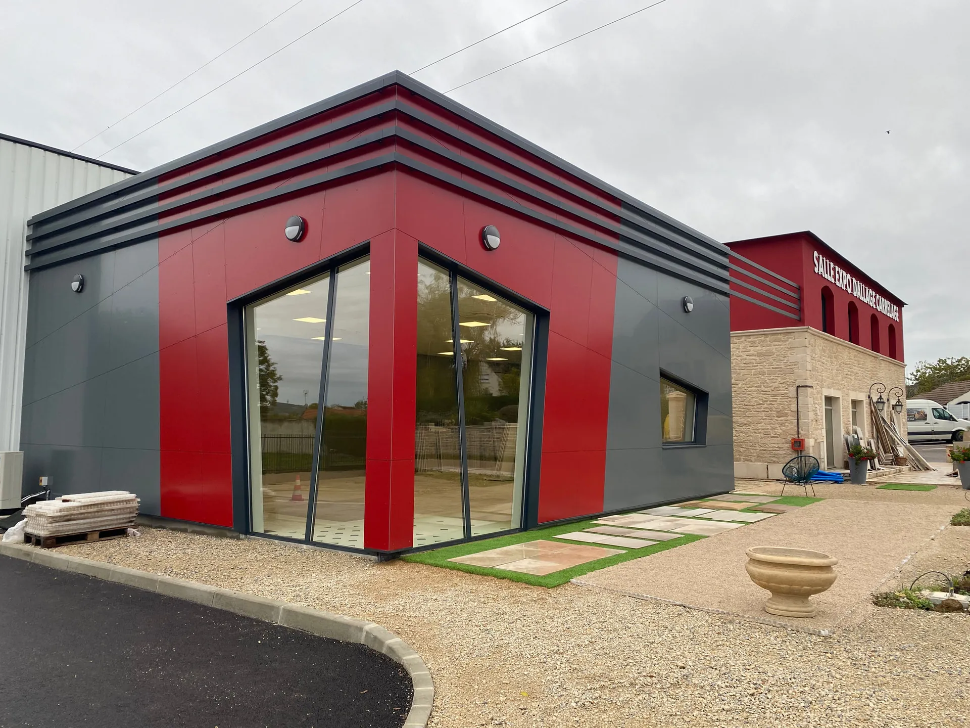 Salle d'exposition habillée en bardage composite rouge et anthracite